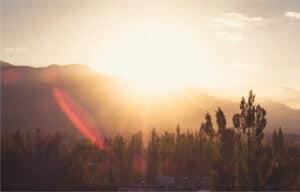 A sunrise over mountains with an almost clear sky