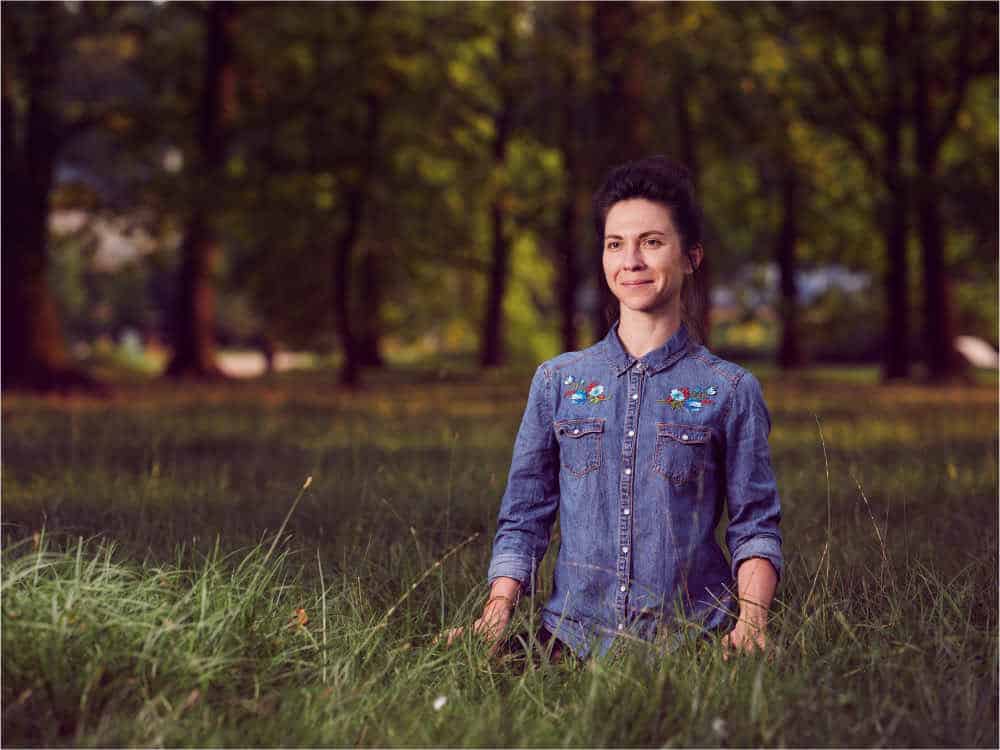 Woman sitting cross-legged in a field meditating