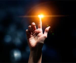 A man's hand with light arising, a symbol of the reminders in Buddhism to practice the path