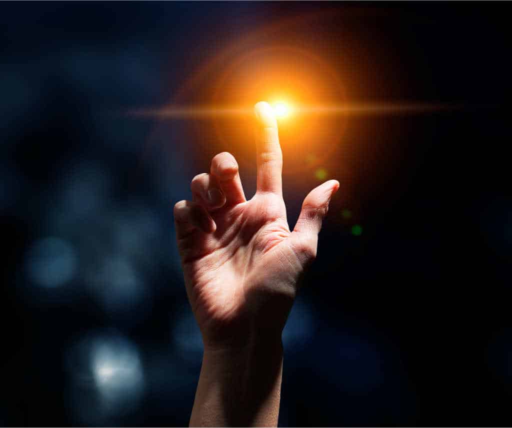 A man's hand with light arising, a symbol of the reminders in Buddhism to practice the path