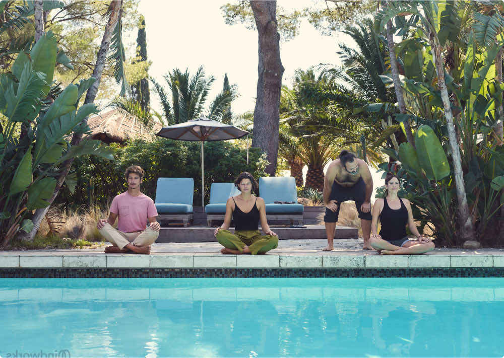 4 friends meditating poolside